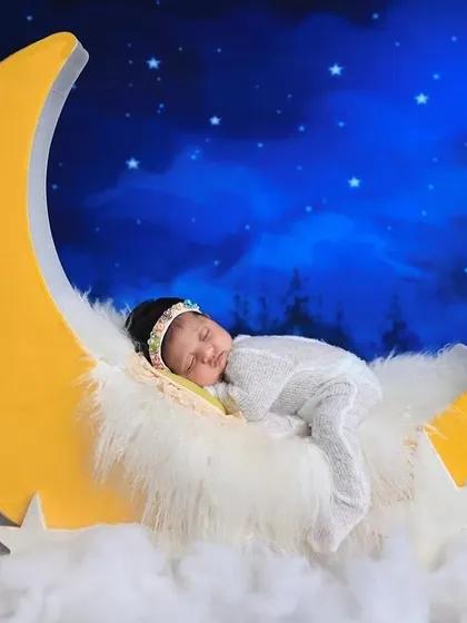 Our 'dreaming on the moon' setup is a whimsical theme that clients love. We use soft, fluffy textures and a starry backdrop to create a magical scene for your sleeping baby.