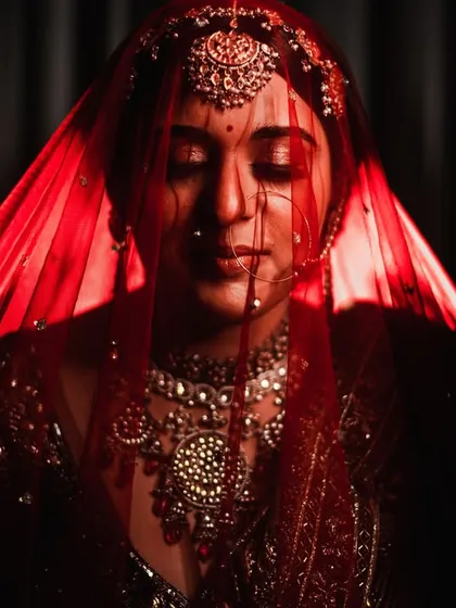 The bride, veiled in red. I use light and shadow to create moody, artistic bridal portraits that are full of emotion and feel like a piece of classic art.