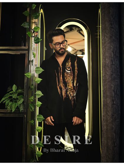 A look of quiet intensity. The tiger print shirt, seen here in a full-length shot, is designed to be the focal point of a powerful, minimalist outfit.