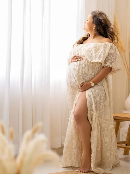 A beautiful solo portrait from a bohemian-themed session, with the mom-to-be basking in the soft window light.