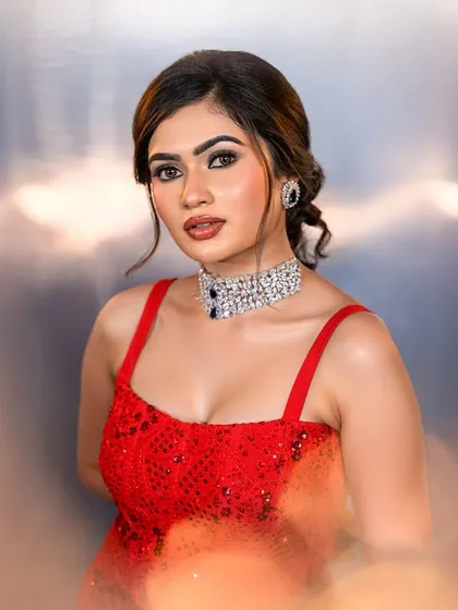A portrait shot of the red gown look, with a soft, diffused background that makes the makeup pop.