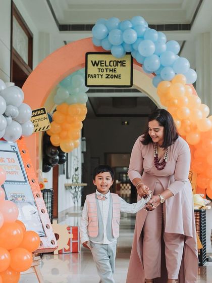 Sidhant and his mother walk through the colorful balloon archway, marking the start of a fun-filled celebration.
