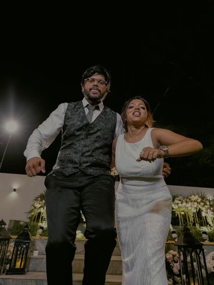 Pure joy and energy as the couple dances during their engagement celebration, captured in a fun, low-angle shot.