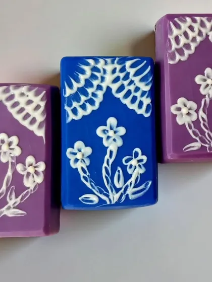 The final look of my brush embroidery challenge soaps. The contrast between the deep blue and purple base and the white piping is quite striking.