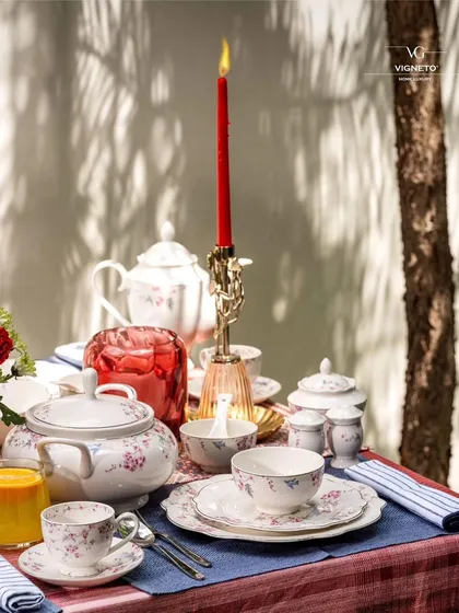 A beautifully styled tablescape with Vigneto's crockery, featuring a striking red candle as a centerpiece. The play of light and shadow across the table creates a dramatic and inviting scene.