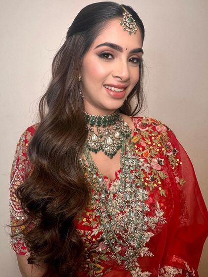A smiling portrait of the bride. Her happiness radiates, and the makeup enhances her features beautifully for the evening's celebration.