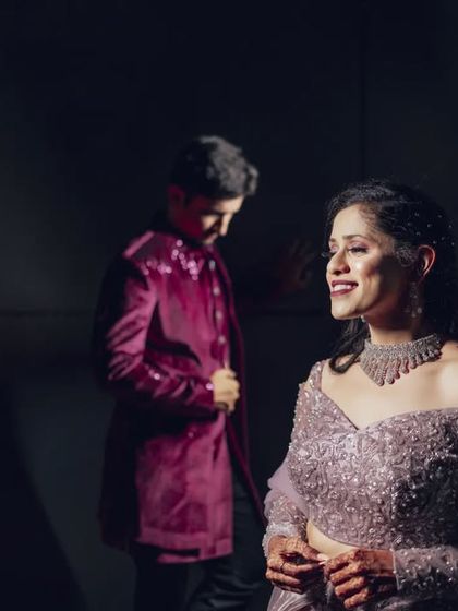 An artistic composition focusing on the bride's happy expression, with the groom softly in the background. This style of portraiture tells a story by playing with focus and depth.