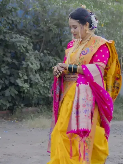 A candid shot of the bride in her stunning yellow and pink Paithani saree, captured in a moment of quiet reflection outdoors.