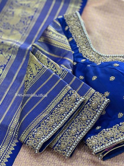 A royal blue blouse with gold striped sleeves and floral embroidery.