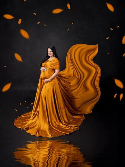 The beauty is in the details. The gentle smile and the way the light catches the satin of the gown create a feeling of warmth and joy in this elegant maternity portrait.