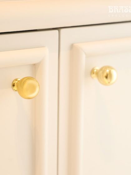A close-up of our Sphere knob in a Polished Brass finish on a white cabinet. This simple, elegant detail adds a touch of luxury and tradition, reflecting our client's appreciation for India's rich cultural heritage.
