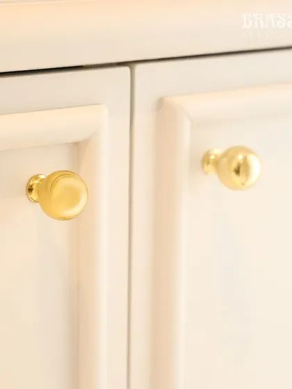 A close-up of our Sphere knob in a Polished Brass finish on a white cabinet. This simple, elegant detail adds a touch of luxury and tradition, reflecting our client's appreciation for India's rich cultural heritage.