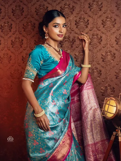 This portrait captures the classic beauty of a South Indian bridal look. The lighting is soft yet detailed, focusing on the texture of the silk saree and the model's serene expression.