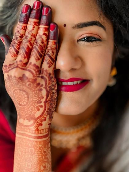 A classic bridal portrait focusing on the bride's expressive eyes and intricate henna design. A simple, beautiful, and timeless shot.