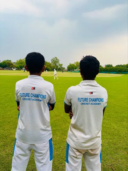A view from the back, showing their academy jerseys. They carry the name "Future Champions" with pride.