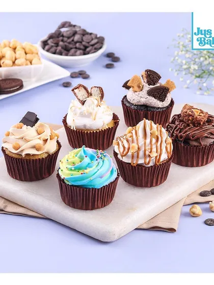 An assortment of our gourmet cupcakes, perfect for any celebration. This selection includes flavors like Oreo, Kit Kat, and Nutella, alongside our colorful rainbow sprinkle cupcake. There's something for everyone.