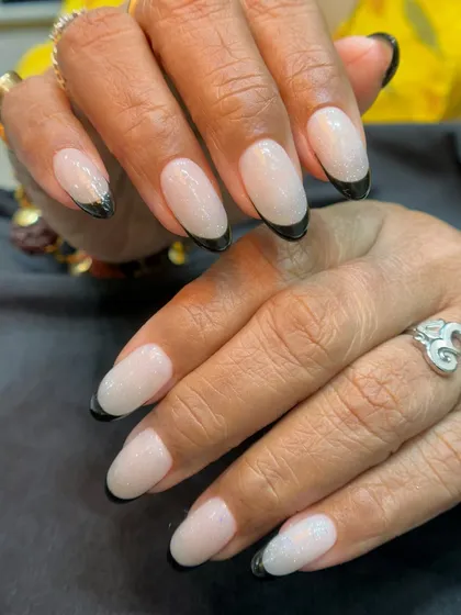 A modern twist on a classic. This look features a milky white base with a sharp, elegant black French tip. It's a bold yet sophisticated style that shows how a simple change can create a big impact.