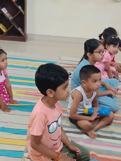 A group of children listens with rapt attention, completely absorbed in the story of the Ant Queen.
