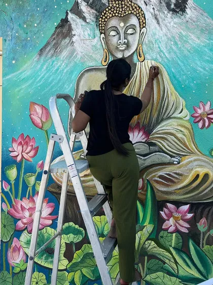 Carefully painting the details on Buddha's face.