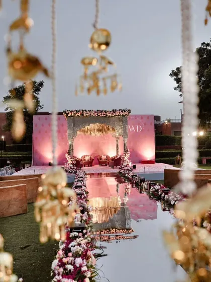 The serene beauty of a mirror aisle just before the ceremony begins. The reflection of the sky and the intricate mandap creates a sense of infinite space and endless possibility.