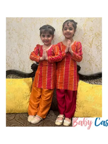 Two sisters ready for a festive celebration in their matching bandhani print salwar kameez sets. These traditional outfits are perfect for Lohri, Diwali, or a family puja.