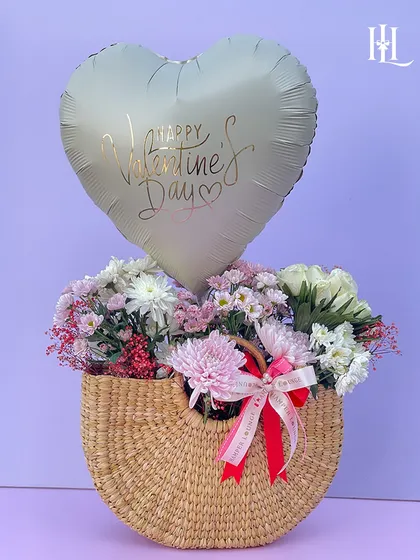 This charming jute bag hamper adds a touch of rustic magic to your Valentine's Day. It's filled with fresh flowers and topped with a "Happy Valentine's Day" balloon for a simple yet beautiful gesture.