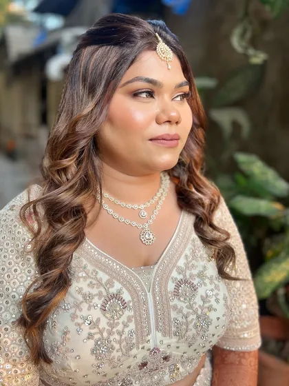 A side profile of this glamorous look, highlighting the soft curls and defined cheekbones.