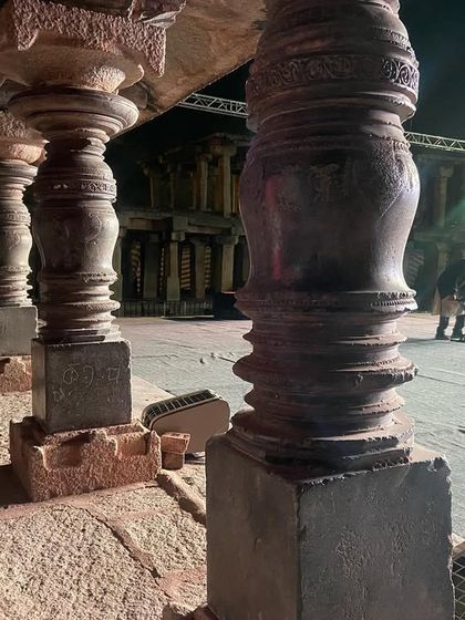 The stage being set amidst the stone pillars of Hampi. Even before the performance begins, the atmosphere is charged with history and anticipation.