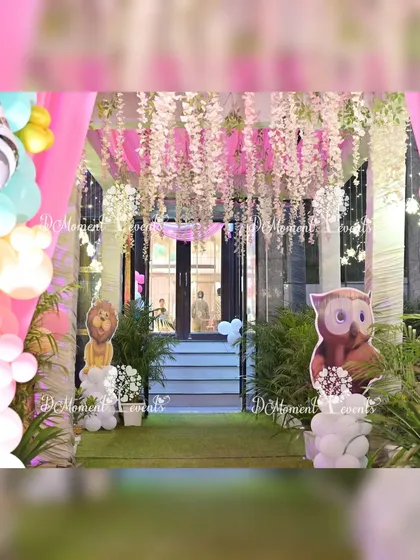A close-up of the jungle party entrance, showing the hanging wisteria and animal cutouts like a lion and an owl, which add to the immersive woodland experience.