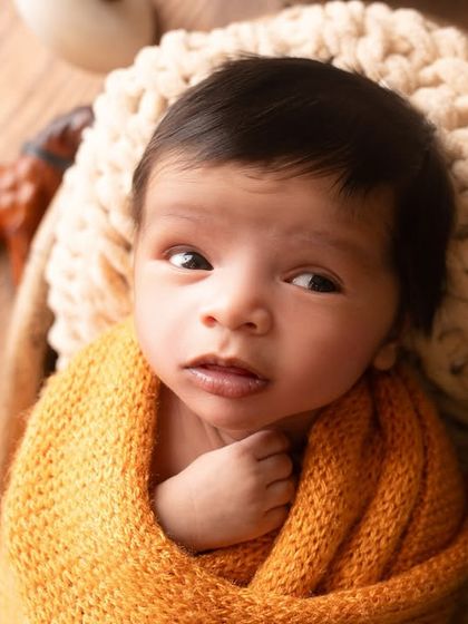 A beautiful awake moment, with the newborn's curious eyes open and looking around. I capture these quiet moments of observation with the same care as the sleepy poses.