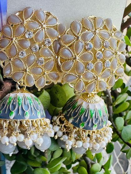 A unique grey Meenakari jhumka with green and white detailing. This is a sophisticated color choice for those who want something different from the usual bright festive colors.