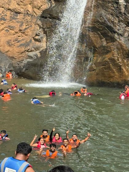 A group of adventurers enjoying a swim at the base of Dudhsagar falls, a truly unforgettable experience.
