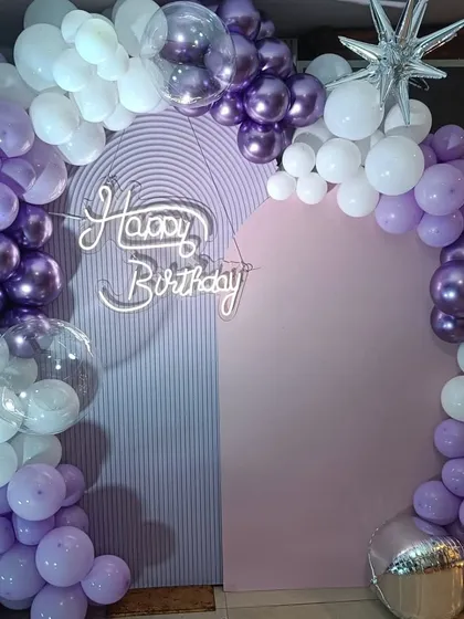 A close-up of the balloon arrangement for the 24th birthday, showing the combination of different shades of purple and white, with clear and chrome balloons added for a touch of elegance.
