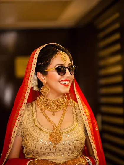 Capturing the personality of the bride is key. This candid shot of a bride adding a fun twist with sunglasses to her traditional attire shows a modern, joyful approach to wedding photography. It’s about those unscripted, happy moments.