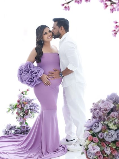 A loving kiss from her partner completes this elegant, purple-themed maternity portrait. It's a beautiful celebration of their journey to parenthood together.