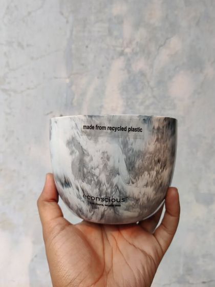 A close-up of our grey marble finish planter, held in hand to show its detail. Each pot is proudly marked 'made from recycled plastic' as a reminder of its sustainable origins.