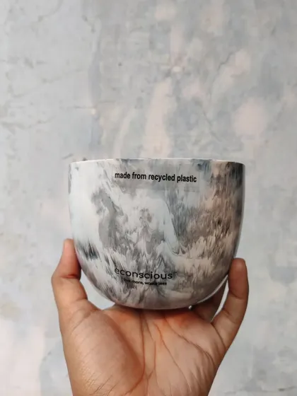 A close-up of our grey marble finish planter, held in hand to show its detail. Each pot is proudly marked 'made from recycled plastic' as a reminder of its sustainable origins.