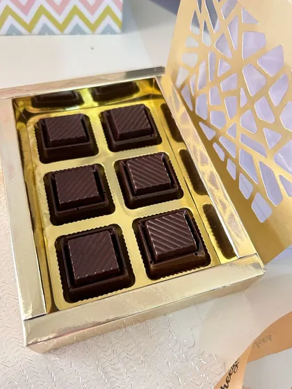 A close-up of the handmade, caramel-filled chocolates included in the Rakhi hamper, presented in a beautiful golden box.