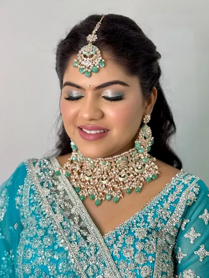 A serene close-up of the eye makeup. The silver and turquoise shimmer is a perfect match for her outfit.