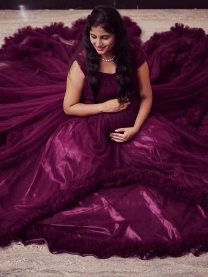 This top-down shot of the deep purple ruffled gown shows how the dress can create a beautiful floral-like pattern around the expecting mother. It's a creative angle for any maternity shoot.