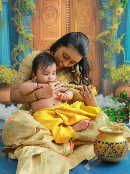 A mother's gentle moment with her baby Krishna. The colorful, festive backdrop of Vrindavan adds a magical touch to this tender portrait.