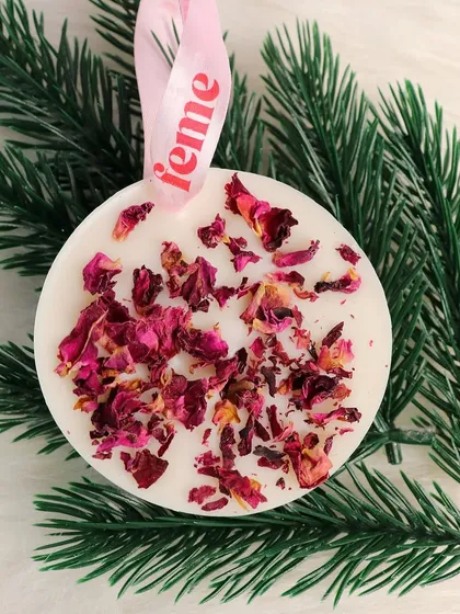 A wardrobe essential. Our rose petal wax sachet hanging on a pine branch, perfect for the festive season.