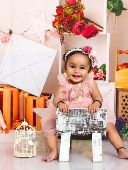 A happy princess in a floral wonderland. Her bright smile and the lovely pink dress make for a cheerful and charming portrait.