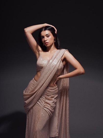 A classic three-quarter pose that exudes confidence. The lighting is carefully sculpted to define the model's form and make the sequined saree shimmer.