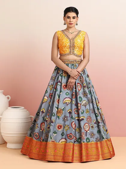 The grey floral lehenga paired with a bright yellow embroidered blouse offers a unique and sophisticated color combination.