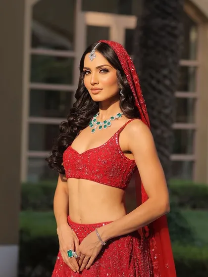 A modern red lehenga look, styled with a simple dupatta drape to keep the focus on the intricate beadwork and the bride's natural beauty.