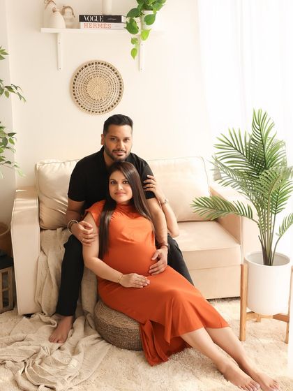 A classic couple portrait with a warm, lifestyle feel. The earthy tones of their outfits and the surrounding decor create a cohesive and inviting image.