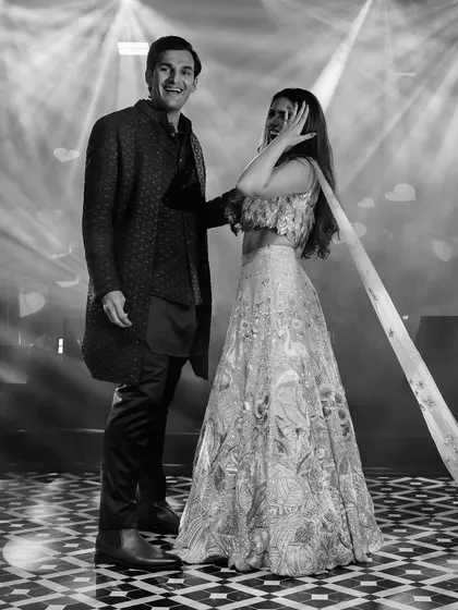 A candid black and white photo of Khushboo and Varddan on the dance floor. The focus is on their joyful interaction and the energy of the moment, stripped of all distractions.