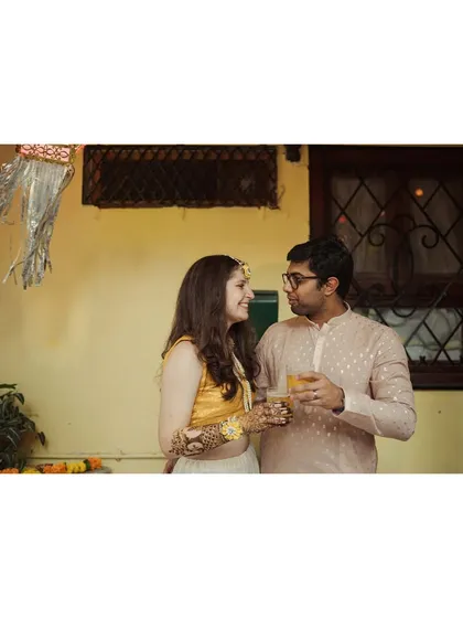 A quiet moment between the couple during the mehendi event, sharing a drink and a look of love.