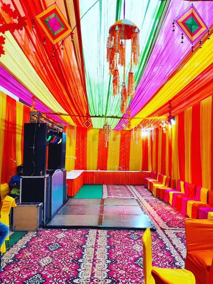 A vibrant tent setup with a small dance floor and DJ console, ready for a Sangeet or Mehendi night party.